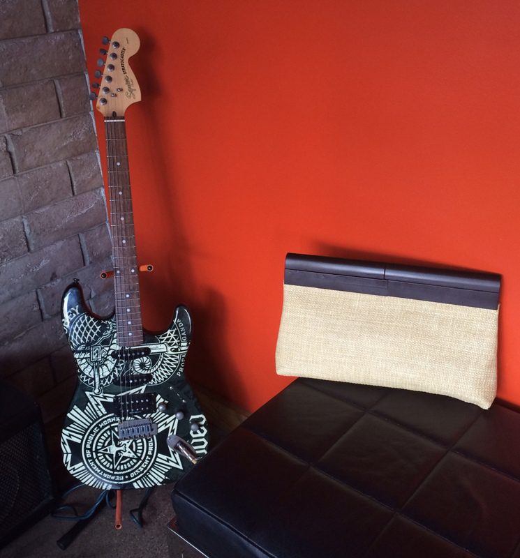 A guitar sitting on top of a black bench.