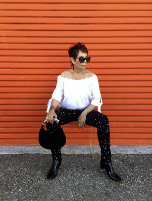 A woman sitting on the ground wearing sunglasses.