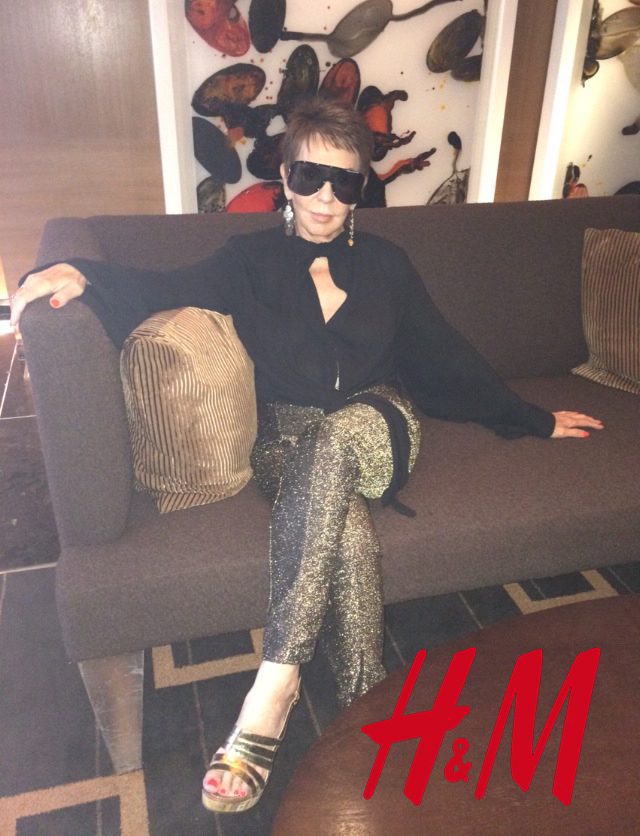 A woman sitting on top of a couch wearing sunglasses.
